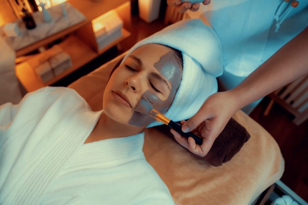Esthéticienne réalisant un soin du visage dans un institut de beauté.