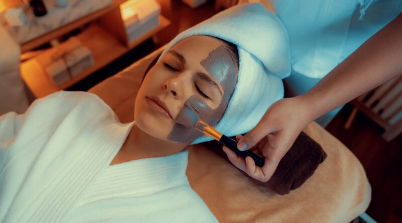 Esthéticienne réalisant un soin du visage dans un institut de beauté.
